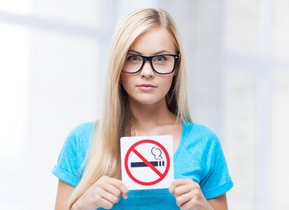 garota segurando uma placa de proibição de fumar na entrada